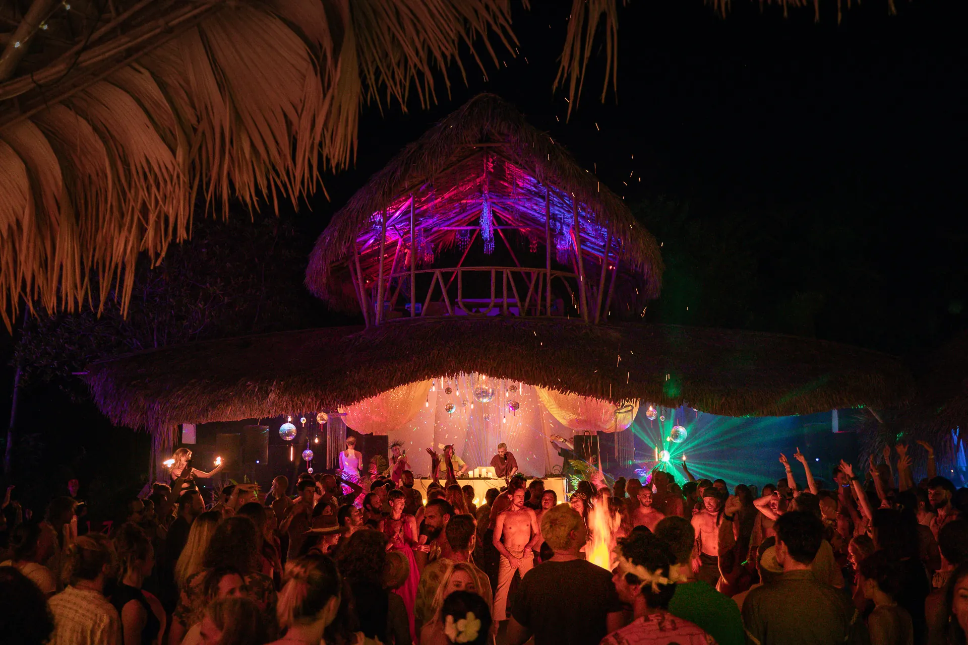 The AUM stage lit up at night above the dance floor